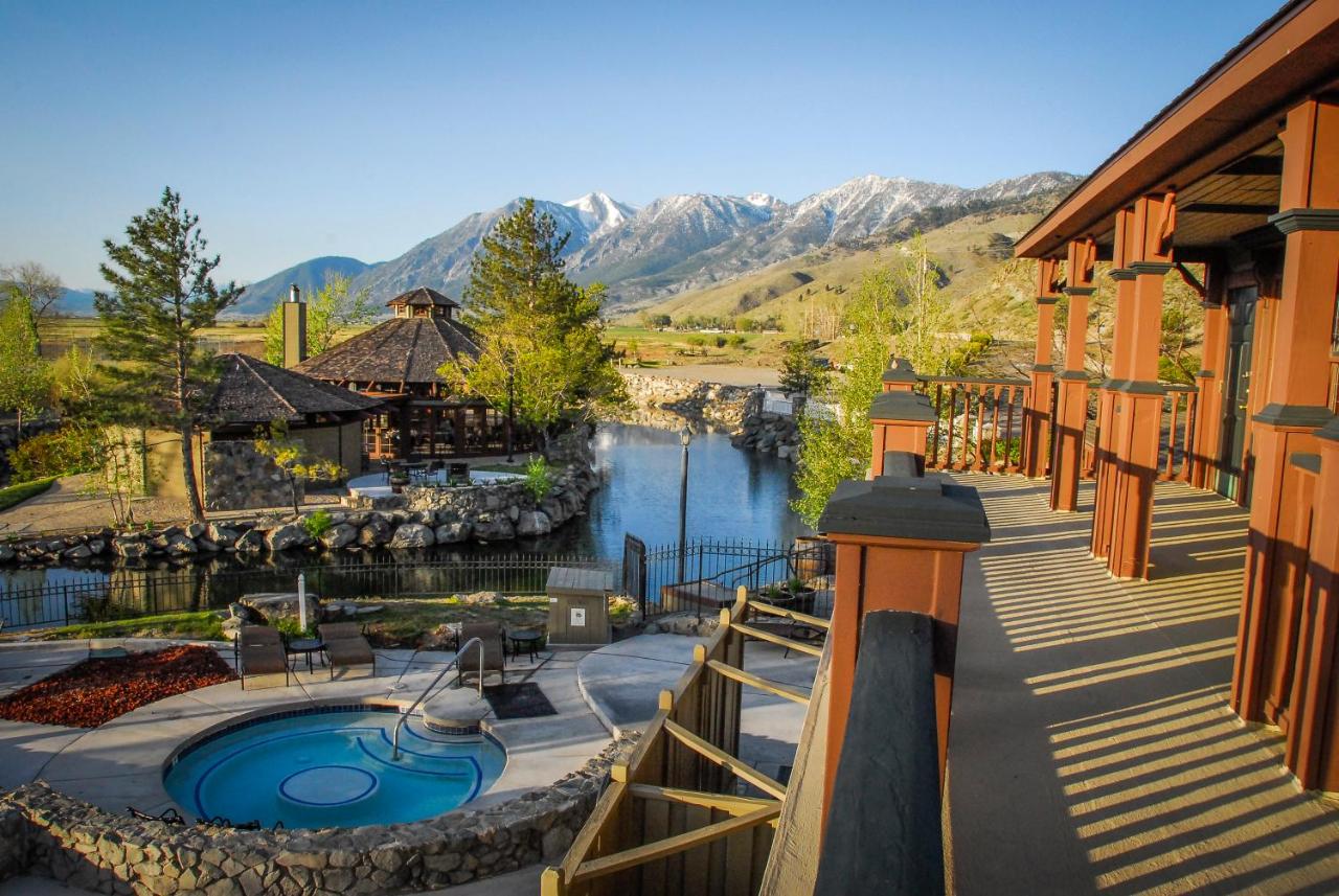 Resort patio with hot tub overlooking a pond and mountains.