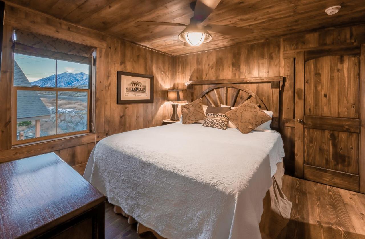 Rustic bedroom with wooden walls and warm lighting.